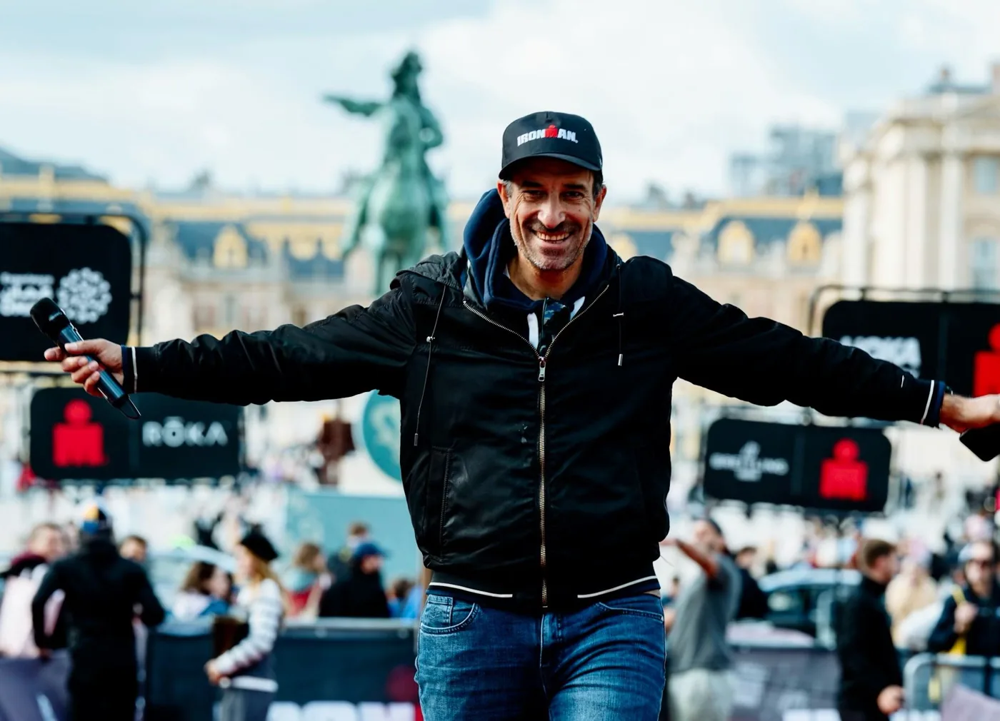 Julien Huët, speaker sportif à l’IRONMAN 70.3 Versailles, micro en main devant le château