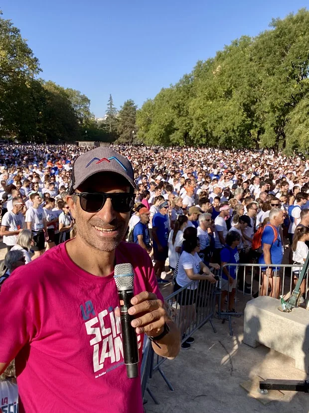 Julien Huët en tee-shirt rose, micro en main devant le public de La Scintillante